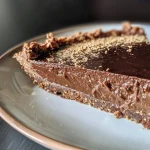 ['Close-up side view of a decadent vegan chai chocolate tart with a glossy chocolate layer.', 'A luscious slice of vegan chai chocolate tart showcasing layers of cocoa and spices.', 'Side profile of a vegan tart highlighting its rich chocolate filling and crust.', 'An inviting vegan chai chocolate tart, emphasizing its smooth texture and vibrant color.']