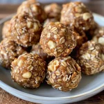 ['A close-up view of delicious Walnut Oatmeal Energy Balls on a wooden surface.', 'Juicy Walnut Oatmeal Energy Balls scattered on a kitchen countertop.', 'A side angle of Walnut Oatmeal Energy Balls with a few ingredients surrounding them.', 'A detailed shot of healthy Walnut Oatmeal Energy Balls showing their texture and ingredients.']